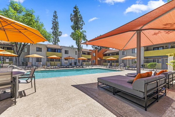 Luxury pool with surrounding lounge chairs at Villatree Apartments, offering modern amenities for relaxation and leisure