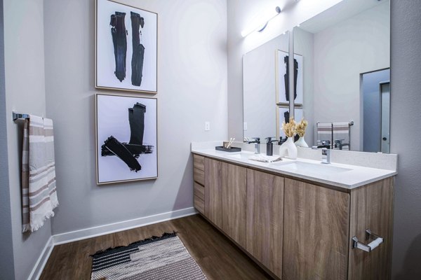 Bathroom featuring modern fixtures and dual sinks at Lynwind Apartments