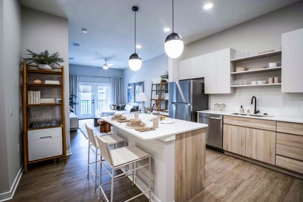 Modern kitchen with stainless steel appliances and granite countertops at Lynwind Apartments