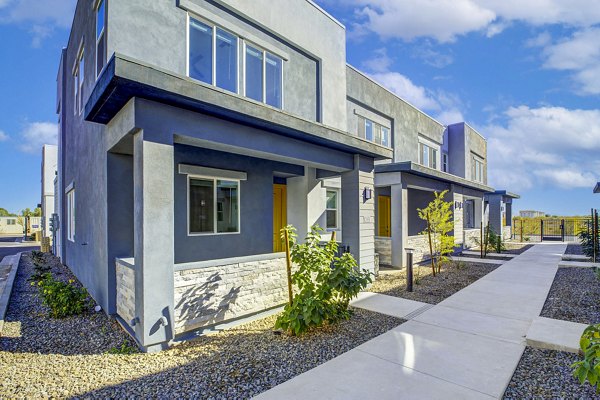 Modern townhouses with lush landscaping and a welcoming pathway in a luxury apartment community