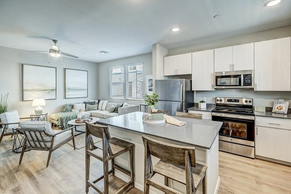 Dining area with modern kitchen finishes in Town Surprise Townhome Apartments