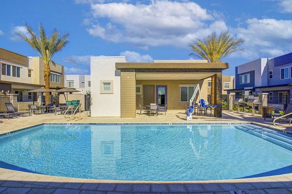 Resort-style pool area at Town Surprise Apartment Townhomes with modern loungers and lush landscaping