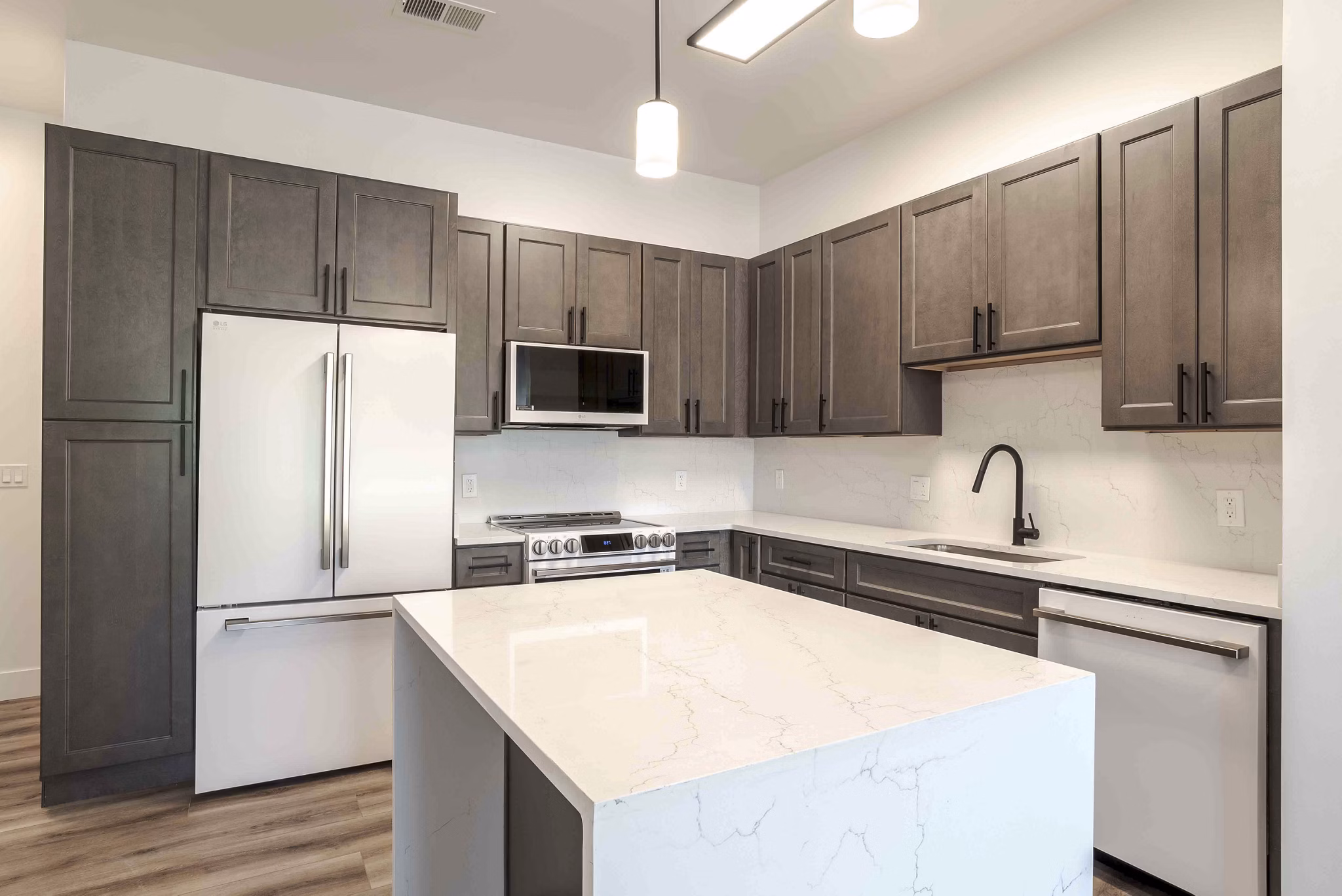 Contemporary kitchen with stainless steel appliances at Midtown 205 Apartments, a luxury community by Greystar