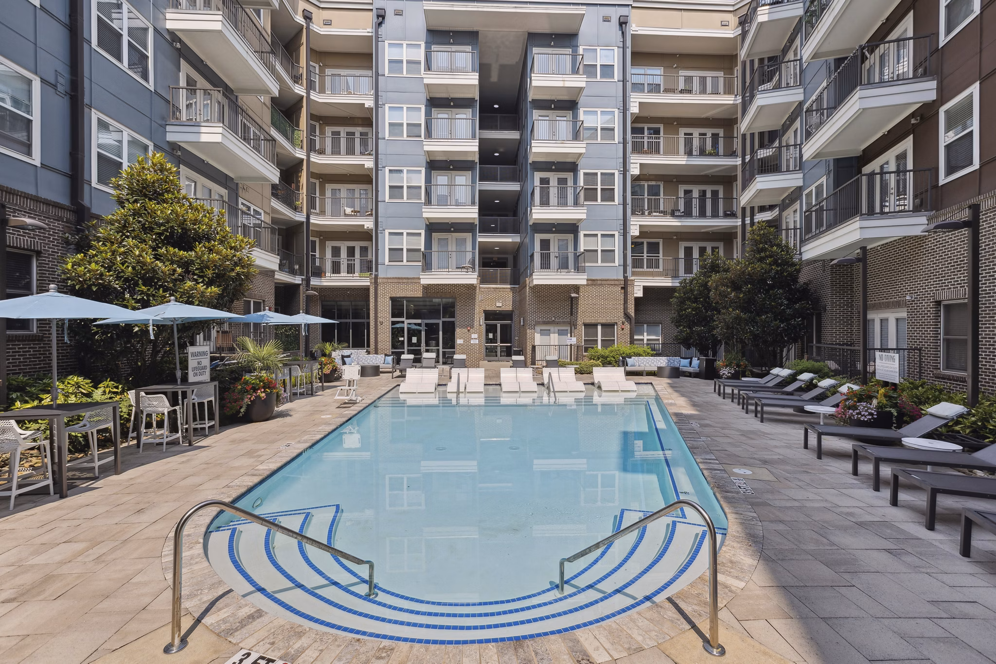 Relaxing poolside deck with lounge chairs at Midtown 205 Apartments offering luxury amenities in a vibrant community setting