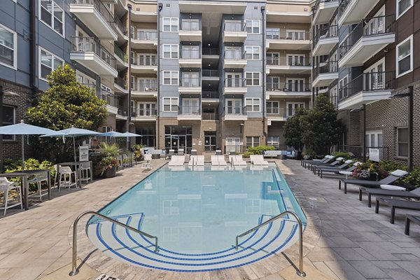 Relaxing poolside deck with lounge chairs at Midtown 205 Apartments offering luxury amenities in a vibrant community setting