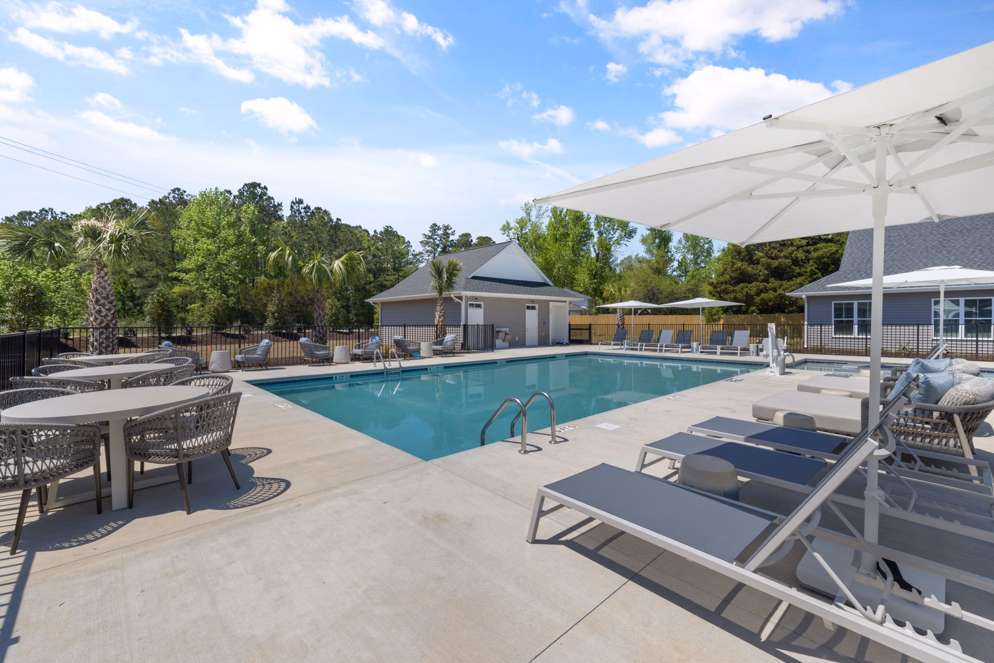 Resort-style pool at Banyan Silo Ridge Apartments, luxury living with palm trees and sun loungers, perfect for relaxation