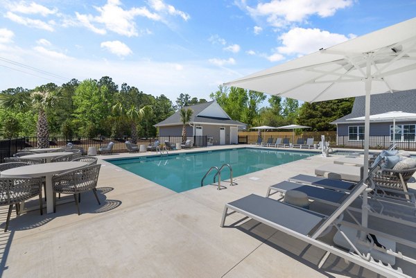 Resort-style pool at Banyan Silo Ridge Apartments, luxury living with palm trees and sun loungers, perfect for relaxation