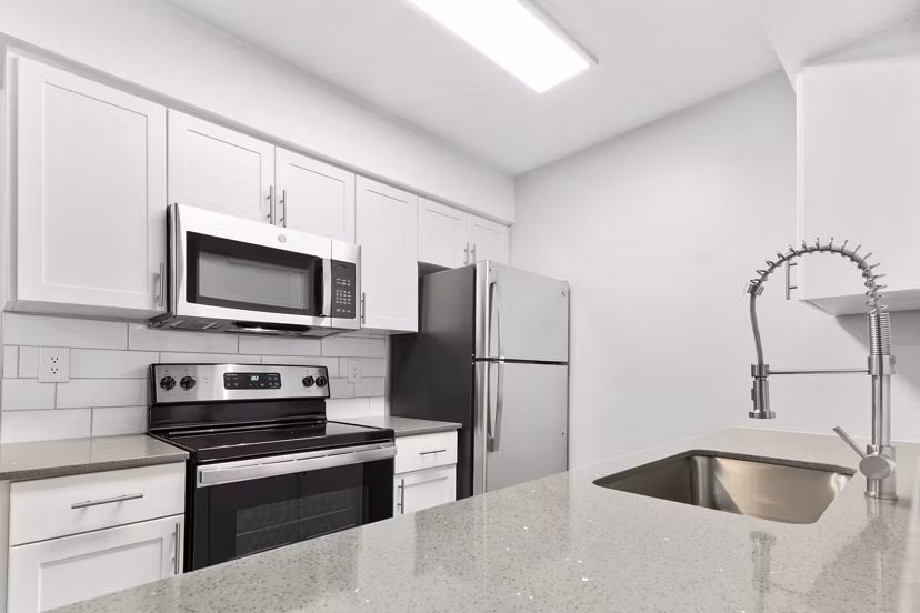 Modern kitchen with sleek appliances and quartz countertops in Verve Apartments