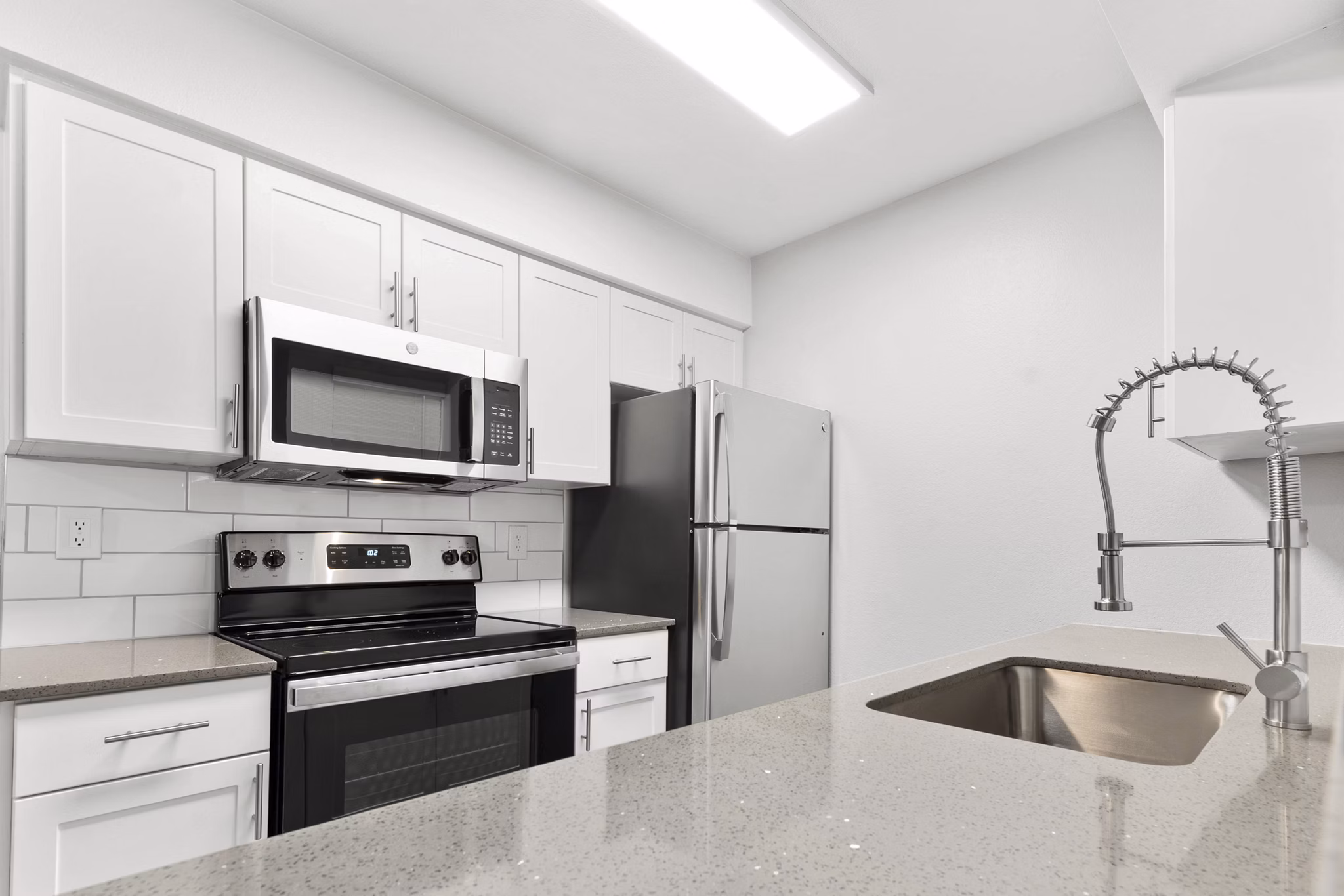 Modern kitchen with sleek appliances and quartz countertops in Verve Apartments