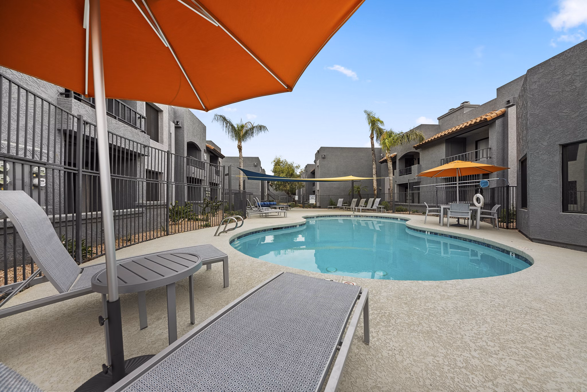 Stylish pool surrounded by lounge chairs at Verve Apartments