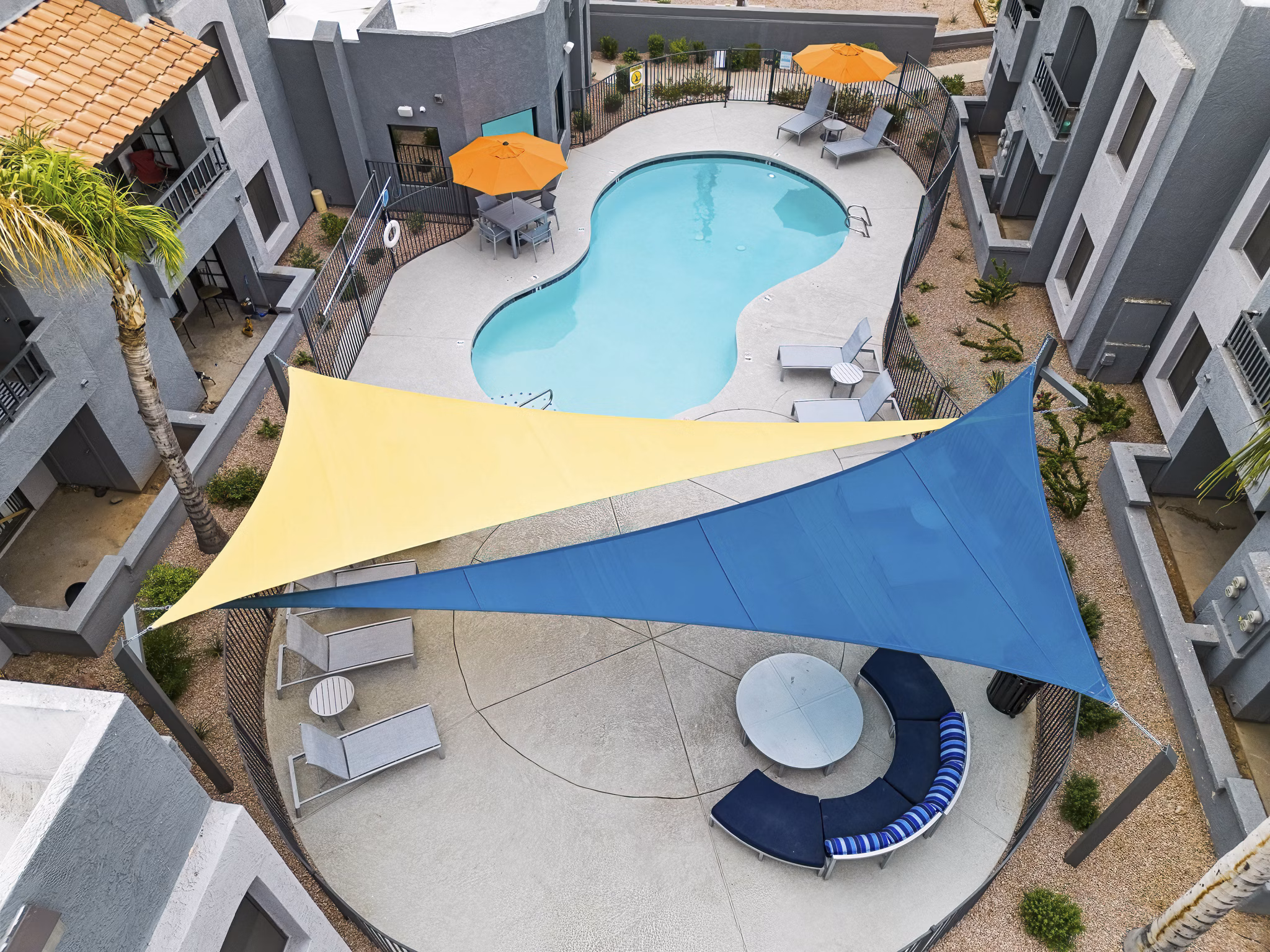 Verve Apartments: Resort-style pool with lounge chairs and garden views