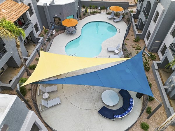 Verve Apartments: Resort-style pool with lounge chairs and garden views