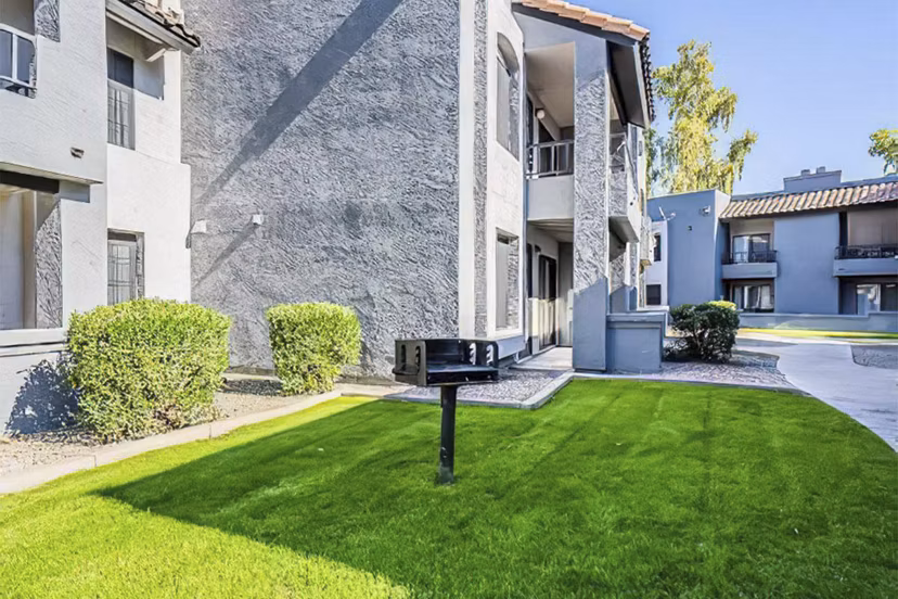 Outdoor grill area with seating and greenery at Verve Apartments