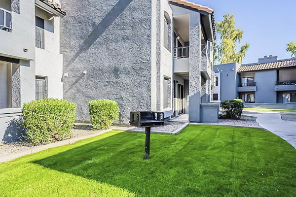 Outdoor grill area with seating and greenery at Verve Apartments