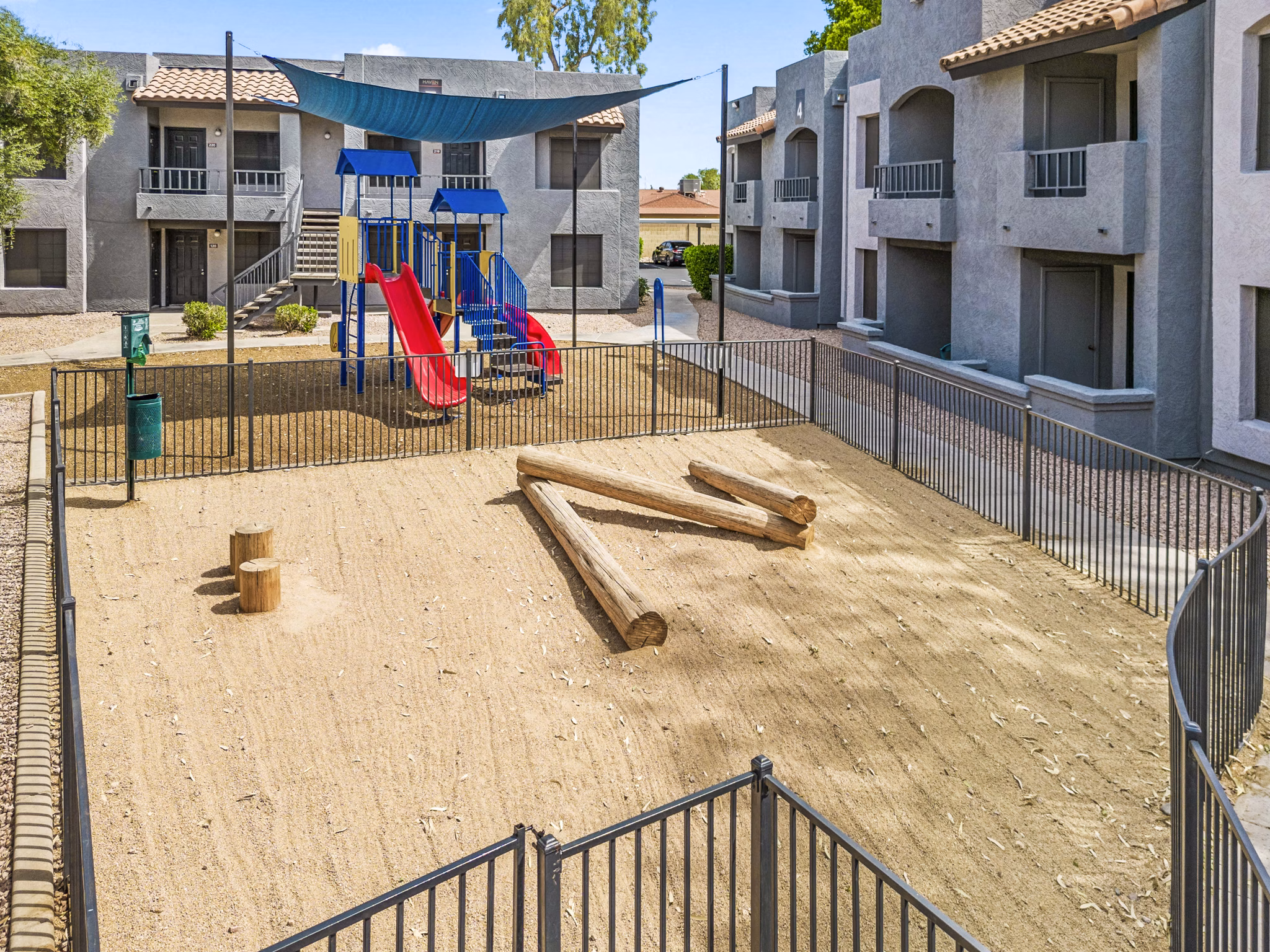 Pet-friendly dog park and children's playground with lush greenery at Verve Apartments, luxury housing community