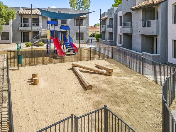 Pet-friendly dog park and children's playground with lush greenery at Verve Apartments, luxury housing community