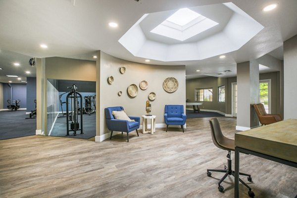 Cozy clubhouse with modern seating and game tables at Cinnamon Tree Apartments