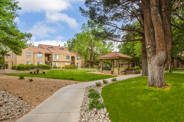 Cinnamon Tree Apartments: Tranquil courtyard with lush greenery and seating areas