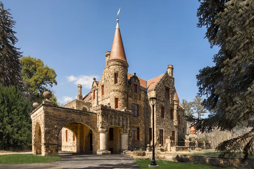 Stone castle-like apartment building with turret and arched entrance in luxury community