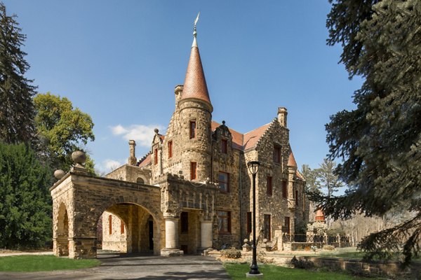 Stone castle-like apartment building with turret and arched entrance in luxury community