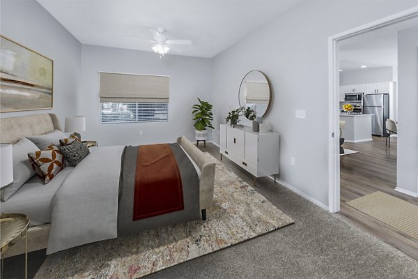 The Village on 5th Apartments: Cozy bedroom with stylish decor and ample natural light in luxury setting