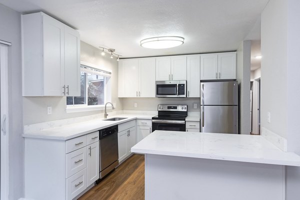 Modern kitchen with granite countertops at Cedar Rim Apartments featuring stainless steel appliances