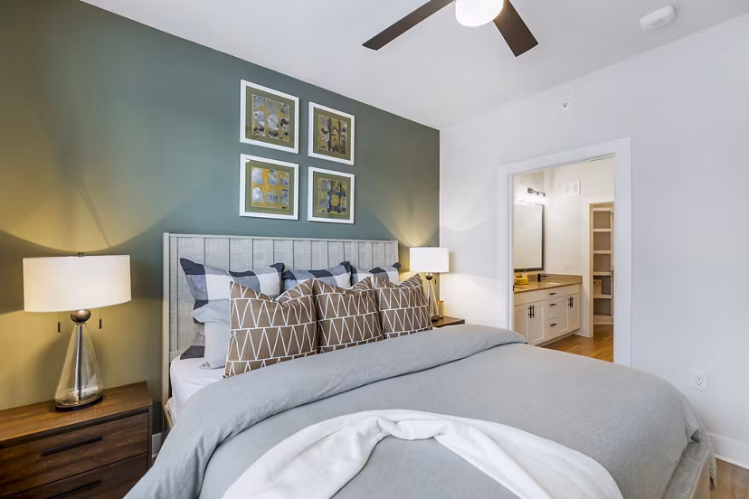 Sleek, modern bedroom with king-size bed and large windows at Elan Harvest Green Apartments, providing comfort and style