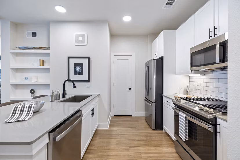 Modern kitchen featuring stainless steel appliances and granite countertops in Elan Harvest Green Apartments