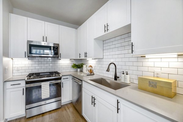 Contemporary kitchen featuring granite countertops and stainless steel appliances in Elan Harvest Green Apartments