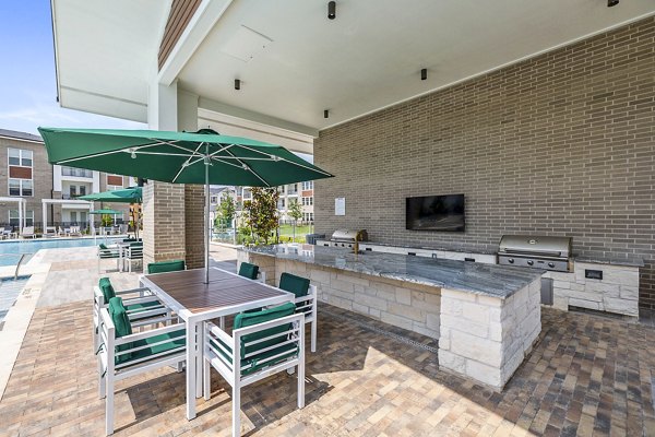 Modern outdoor grill area on patio at Elan Harvest Green Apartments