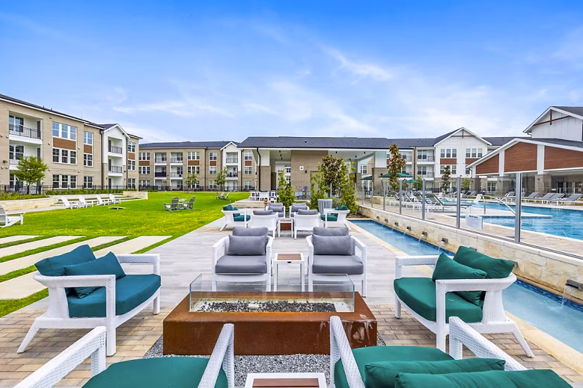 Fire pit and outdoor seating on the patio at Elan Harvest Green Apartments, offering a cozy relaxation space in a luxury community