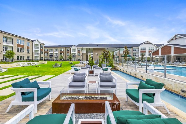 Fire pit and outdoor seating on the patio at Elan Harvest Green Apartments, offering a cozy relaxation space in a luxury community