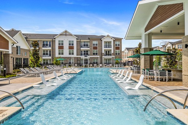 Luxurious pool area with lounge chairs at Elan Harvest Green Apartments