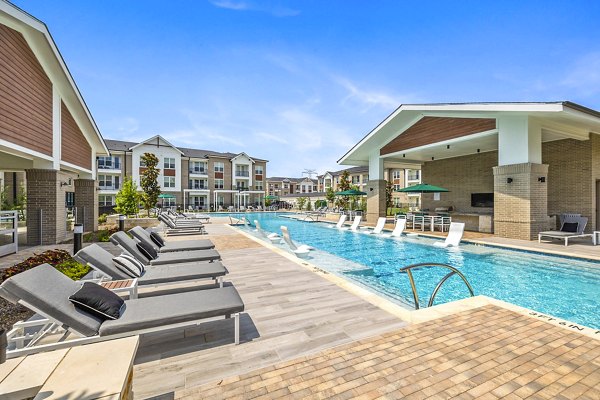 Modern lap pool at Elan Harvest Green Apartments featuring lush landscaping and poolside seating, perfect for relaxation and recreation