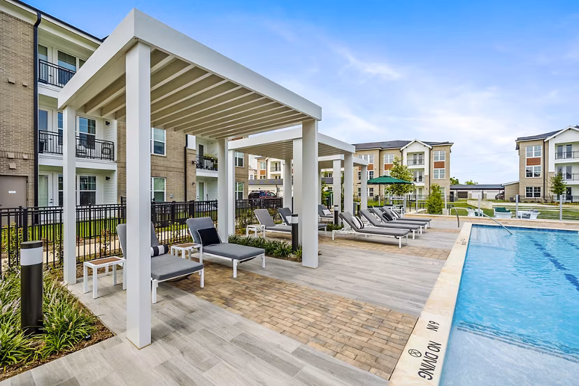 Resort-style pool with lounge chairs at Elan Harvest Green Apartments, offering a luxury living experience