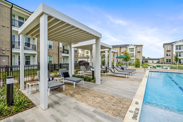 Resort-style pool with lounge chairs at Elan Harvest Green Apartments, offering a luxury living experience
