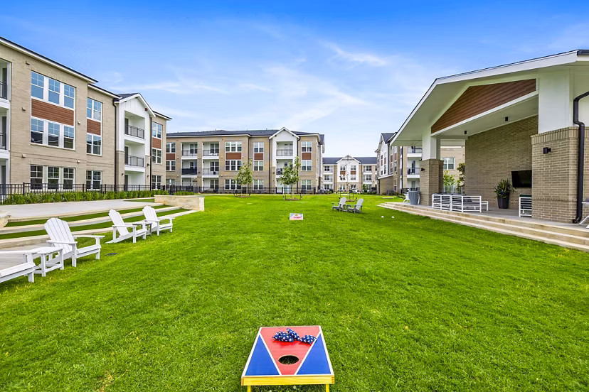 Outdoor recreational patio area at Elan Harvest Green Apartments with seating and greenery, perfect for relaxation and social gatherings