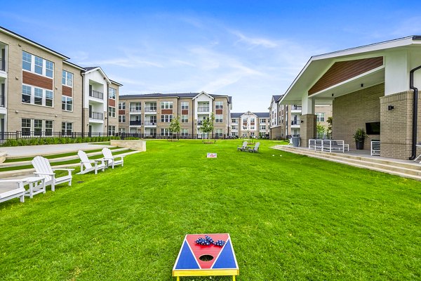 Outdoor recreational patio area at Elan Harvest Green Apartments with seating and greenery, perfect for relaxation and social gatherings