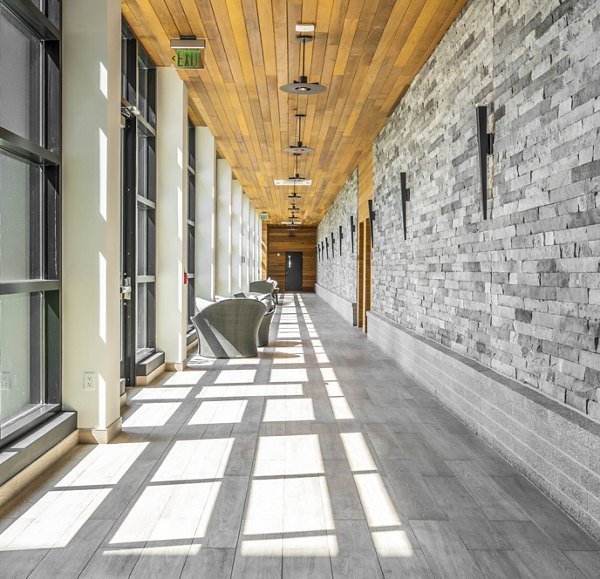 Clubhouse hallway with modern decor and lighting at Avenu at Natick Apartments