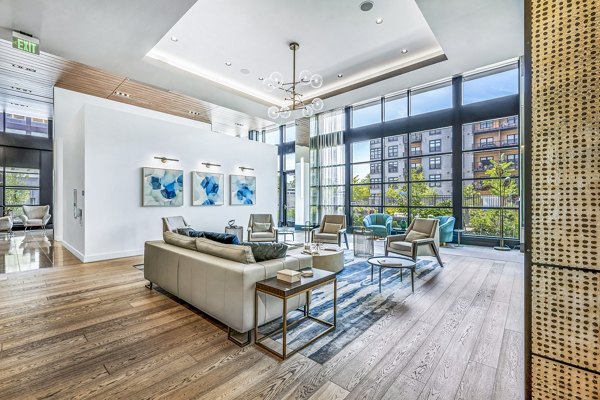 Avenu at Natick: Stylish clubhouse with modern decor and seating, perfect for social gatherings and relaxation at luxury apartments