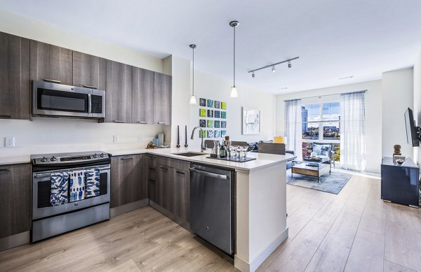 Modern kitchen with stainless steel appliances and granite countertops at One North of Boston Apartments