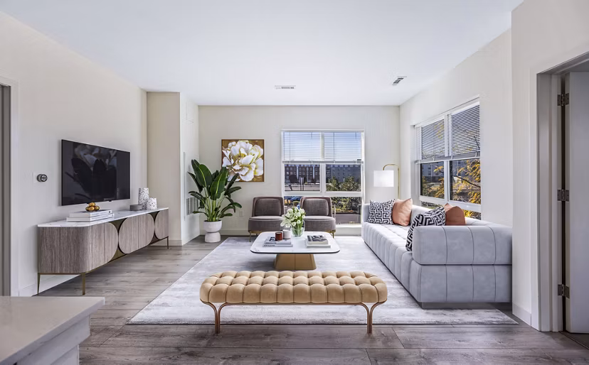 Bright living room with hardwood floors and modern furnishings at One North of Boston Apartments