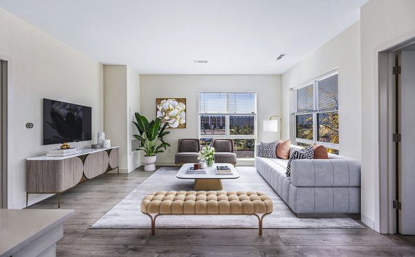 Bright living room with hardwood floors and modern furnishings at One North of Boston Apartments