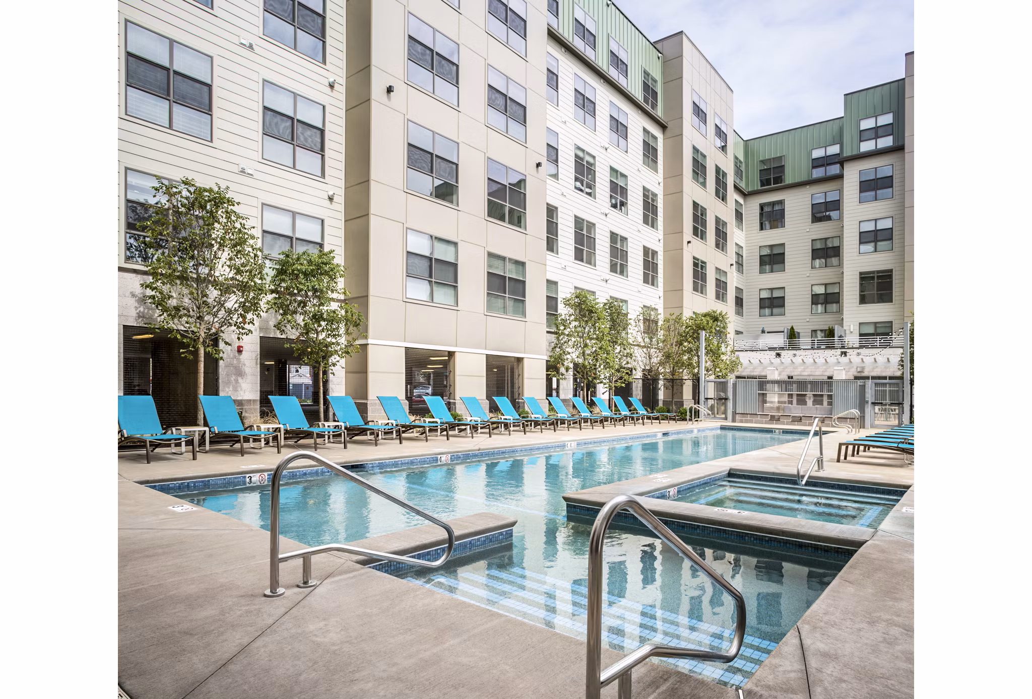 Outdoor swimming pool with lounge chairs at One North of Boston Apartments, a luxury residential community featuring state-of-the-art amenities