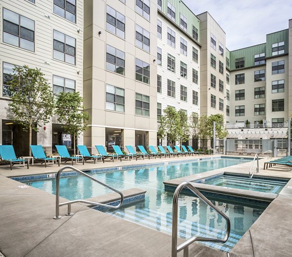 Outdoor swimming pool with lounge chairs at One North of Boston Apartments, a luxury residential community featuring state-of-the-art amenities