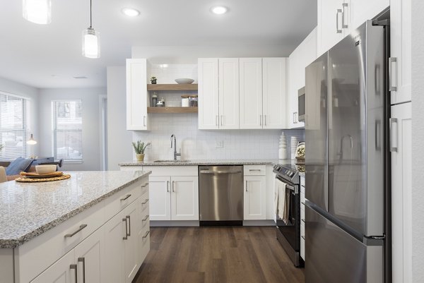 Modern kitchen with granite countertops and stainless steel appliances at Broadstone Wren Apartments