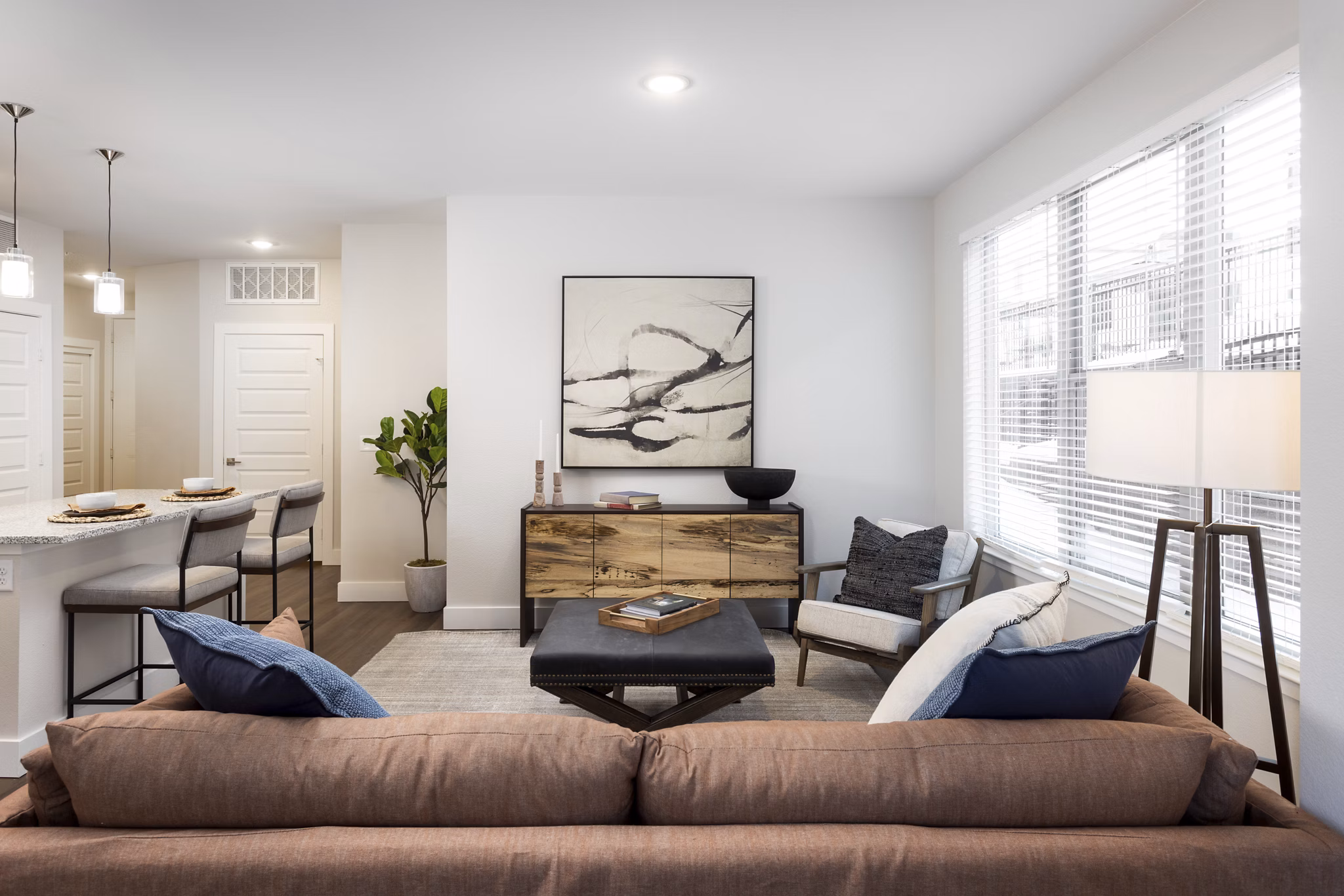 Modern living room with plush seating and large windows at Broadstone Wren Apartments, offering luxury and comfort in urban living