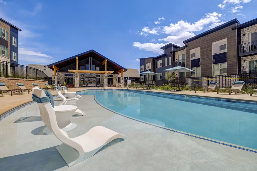 Luxurious pool with lounge seating at Broadstone Wren Apartments, ideal for relaxation in a modern, high-end setting