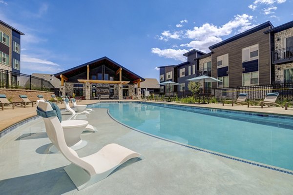 Luxurious pool with lounge seating at Broadstone Wren Apartments, ideal for relaxation in a modern, high-end setting