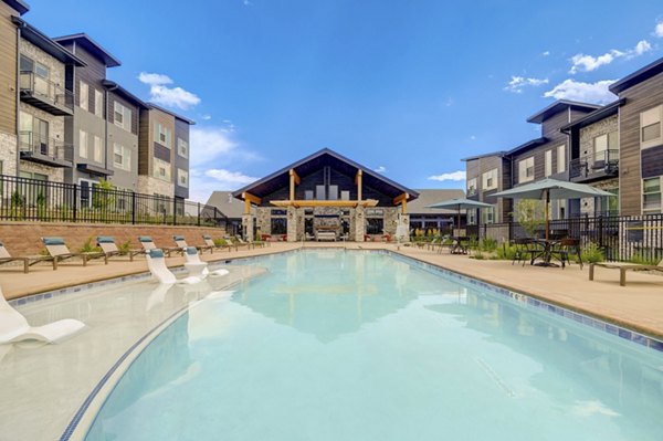 Luxurious outdoor pool area at Broadstone Wren Apartments with lounge chairs and greenery